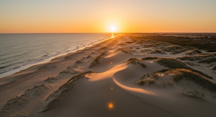 Fototapeta premium Golden Hour Sunset Dunescape - Serene sunset over sandy beach and rolling dunes. Symbolizing peace, tranquility, natural beauty, golden hour magic, and coastal serenity
