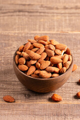 Raw peeled almonds in brown bowl