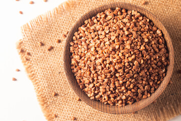 Buckwheat groats on wooden background. Healthy cereal concept.  