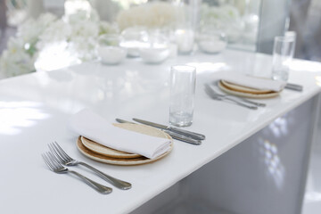 Wedding decorations made of white flowers and candles. Setting the table for the bride and groom.