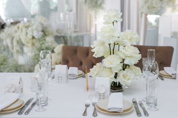 Wedding decorations made of white flowers and candles. Setting the table for the bride and groom.