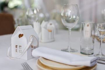 Wedding decorations made of white flowers and candles. Setting the table for the bride and groom.
