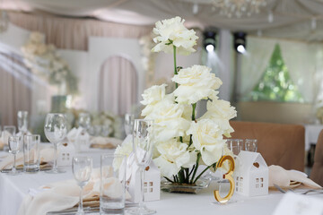 Luxurious table decoration and serving for wedding guests with indication of the table number.
