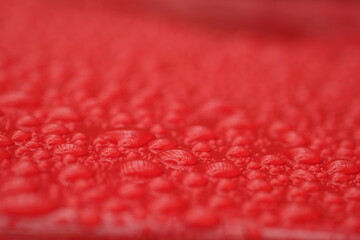 water droplets on the surface of a red background 