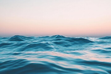 Obraz premium Waves gently lap at the shore under a pastel sky during twilight near a tranquil ocean