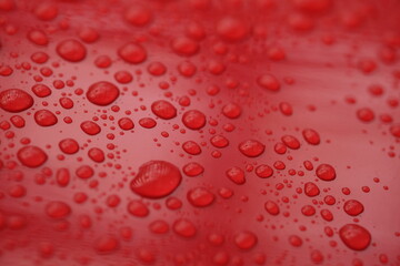 water droplets on the surface of a red shiny surface