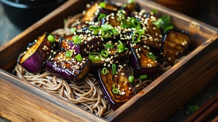 Asian-inspired boxed meal with soba noodles, miso-glazed eggplant, and sesame seeds, authentic flavors in a healthy package.