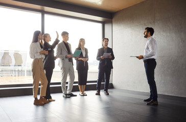 Business team talking during meeting in empty office conference room, brainstorming in co-working space with large panoramic window, project leader talking to colleagues, choosing best candidate