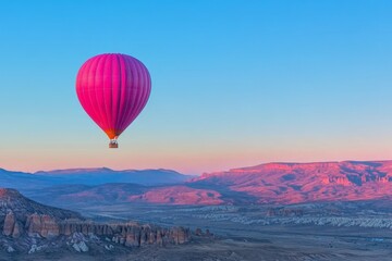 Fototapeta premium Colorful hot air balloon floats over valley at sunrise in Cappadocia, Turkey