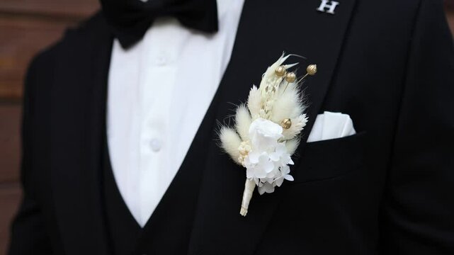 groom in a black suit with a boutonniere