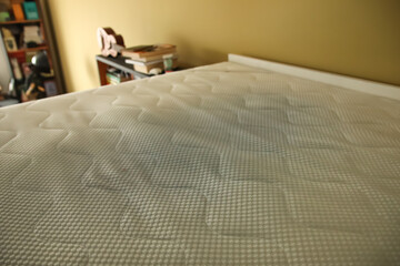 Dirty mattress pad on bed. stained and moldy protector showing signs of age and neglect, highlighting home hygiene, health risks, and the need for replacement or cleaning