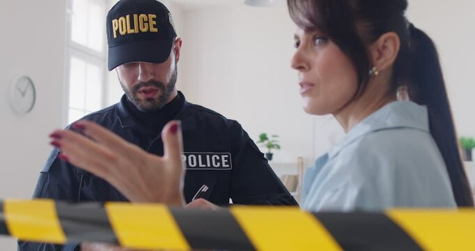 Police officer, member of police force asking woman at crime scene barricade tape, yellow police line, safety warning, police officer, policeman making and processing arrest of young guilty woman