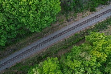 Top down view of railroad tracks surrounded by dense tree growth