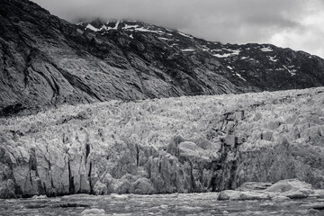 Cold sloping land and low clouds over Dawes Glacier in Alaska