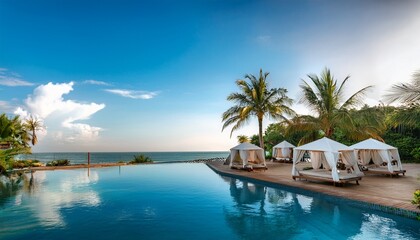 Fototapeta premium luxurious poolside resort with canopy beds and tropical palm trees by the ocean