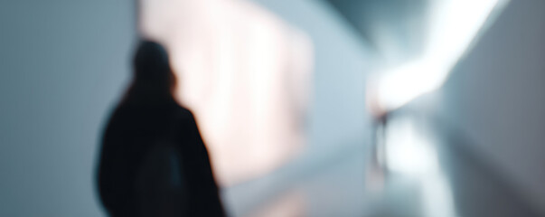 person walking through modern, blurred art gallery hallway