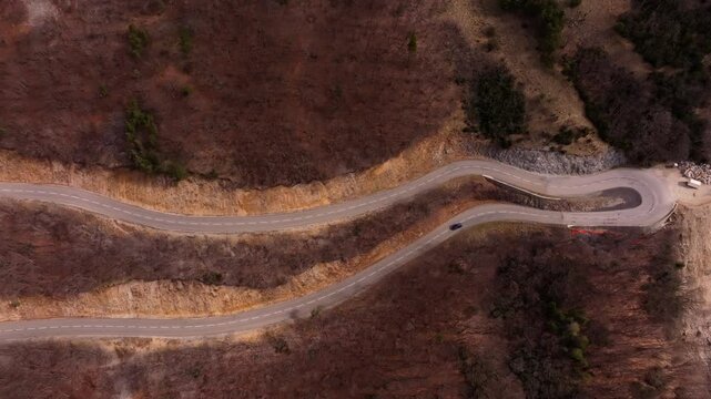 Road carves through Vercors heights in drone flight. Aerial drone video