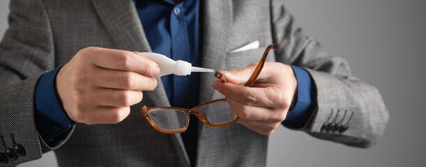 Caucasian man glues eyeglasses. Repairing