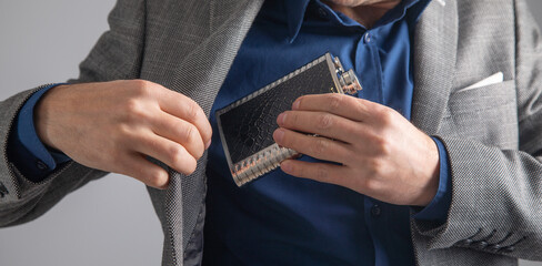 Man holding flask alcohol container.