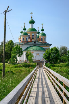 Wooden bridge leading to the Cathedral of Our Lady of Smolensk on an island among the woods in Olonets, Karelia, in summer