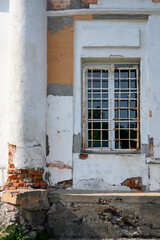 A dilapidated wall with a window and a column of a medieval church