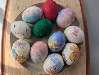  bunch of colorful Easter eggs decorated with various patterns and placed in a bowl at home