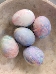  bunch of colorful Easter eggs decorated with various patterns and placed in a bowl at home