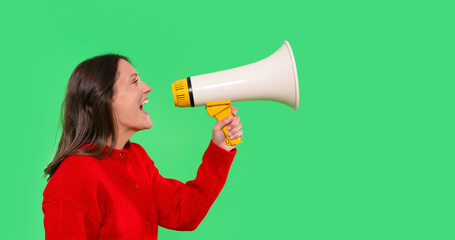 Woman enthusiastically using a megaphone to convey a message with vibrant green background during a creative project