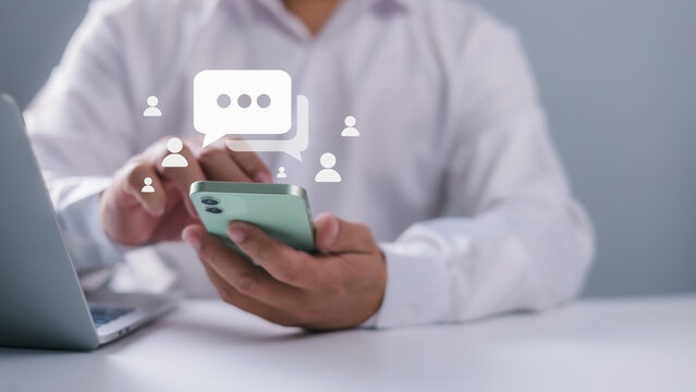 Businessman hand using smartphone typing Live chat chatting and social network concepts, Social media marketing technology concept, Chatting conversation working at home in chat box icons pop up. - Powered by Adobe