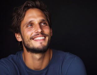 Fototapeta premium A handsome man with a smile, displaying white teeth and good oral hygiene, stands out against a dark black background, embodying motivation, cheerfulness, and attractiveness in a studio setting