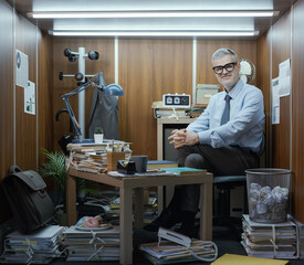 Portrait of a funny businessman working in a tiny messy office