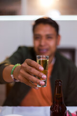 Young man toasting with tequila shot for cinco de mayo celebration