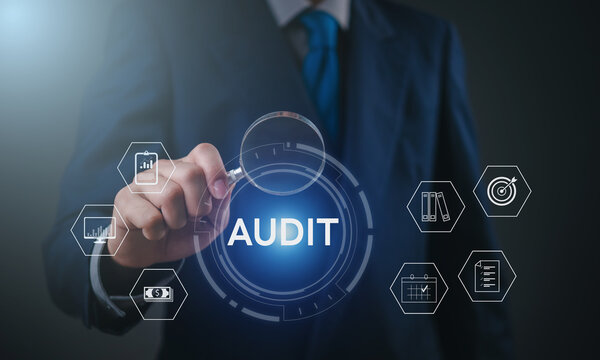 Businessman performing financial audit with magnifying glass on digital dashboard using virtual interface, showcasing data analysis, compliance, and corporate risk management.