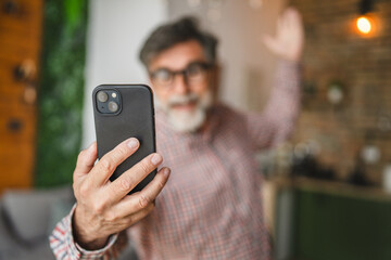 senior man have video call on mobile phone stand at home