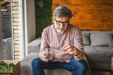 senior man take drug tablet drink painkillers, health care concept