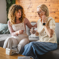 daughter takes care of sick mother with high blood pressure