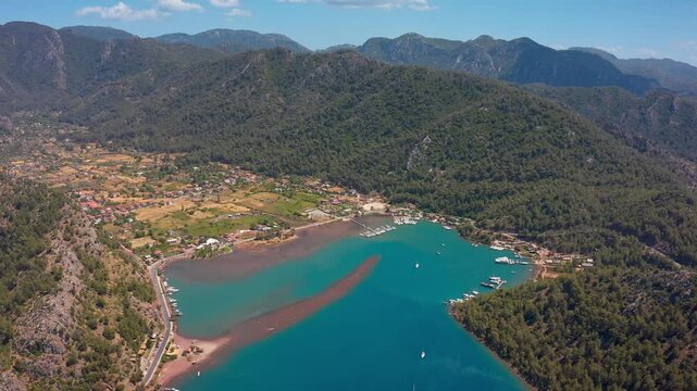 Kızkumu Beach and its surroundings, turquoise waters, lush green mountains and settlements along the coastline reflect the enchanting atmosphere of this natural wonder.