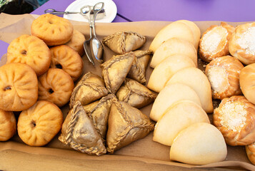 Echpochmak is a traditional Tatar dish. Meat triangular pies with potatoes, meat, onions with copy space on a light background. National Muslim pastries.