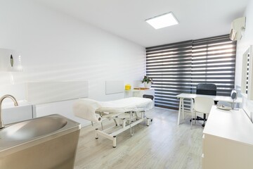 Contemporary medical consultation room with exam table and modern furnishings.