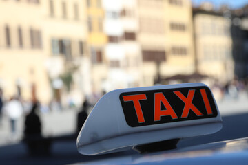 sign above the car with the red word TAXI on the city square waiting for travellers © ChiccoDodiFC