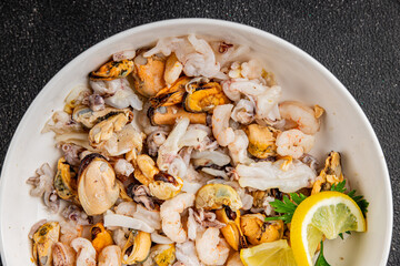 Seafood mix frut de mer mussels, shrimp, prawn, rapan, squid dish fresh gourmet food background on the table rustic food top view copy space keto  paleo diet vegetarian pescetarian diet