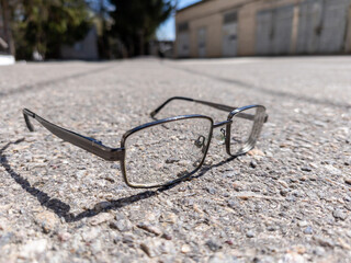 A pair of glasses laying on the ground in front of a building