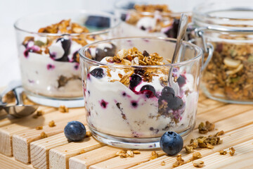 glasses with healthy breakfast with blueberries, yogurt and granola, closeup