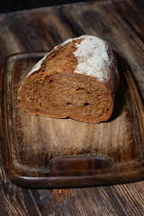 half rye bread on a wooden cutting board, top view