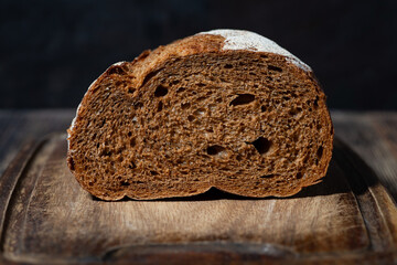 half rye bread on a wooden cutting board, close-up