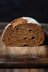 half rye bread on a wooden cutting board,closeup vertical