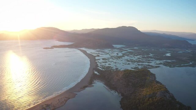 Breathtaking bird's eye view of Iztuzu Beach, captured by drone. Golden sands illuminated by the last rays of the sun, gently rippling sea and waterways forming the delta