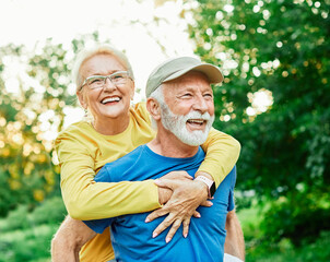 outdoor senior fitness woman man love active fun piggyback exercise healthy fit sport retirement...