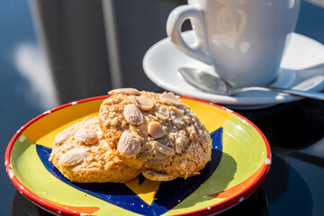 Almond Cookies served in colorful plate with a cup of coffee. A delightful pair of almond cookies, tasty treats combine crunchy textures with sweet flavors, ideal for any occasion