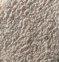 A close up of a fuzzy, white carpet with a grainy texture